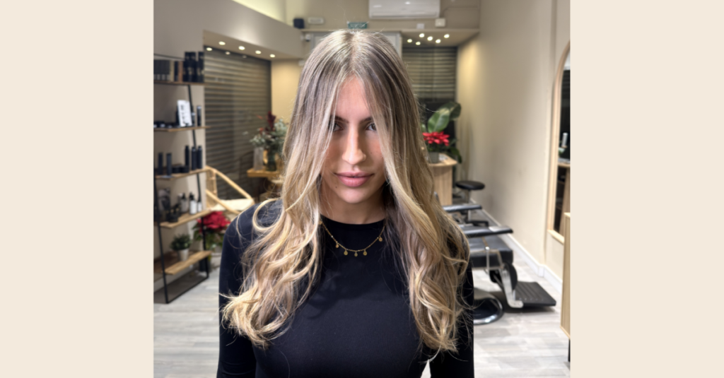 Una mujer mostrando de frente su balayage con babylights dentro de Noon Salón, una peluquería especializada en rubios en Barcelona.